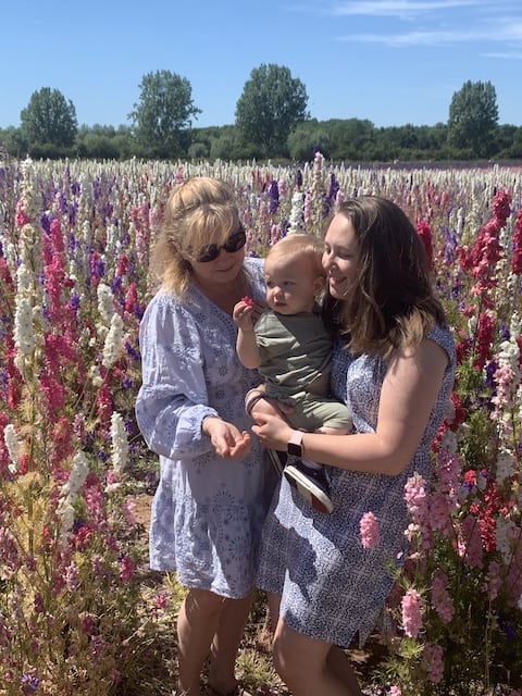 My mum, Rory and I in the confetti fields with Rory looking at a pink flower