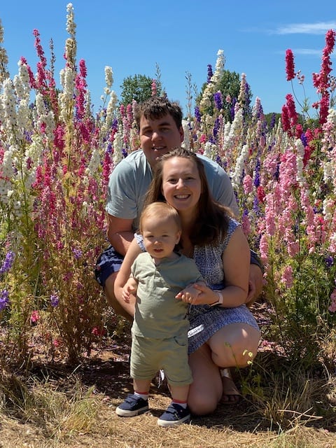 Family photo in the confetti fields. Delphinium flowers against a blue sky